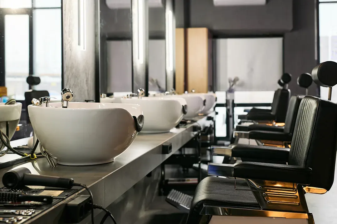 A row of basins and chairs in an empty barbershop before opening